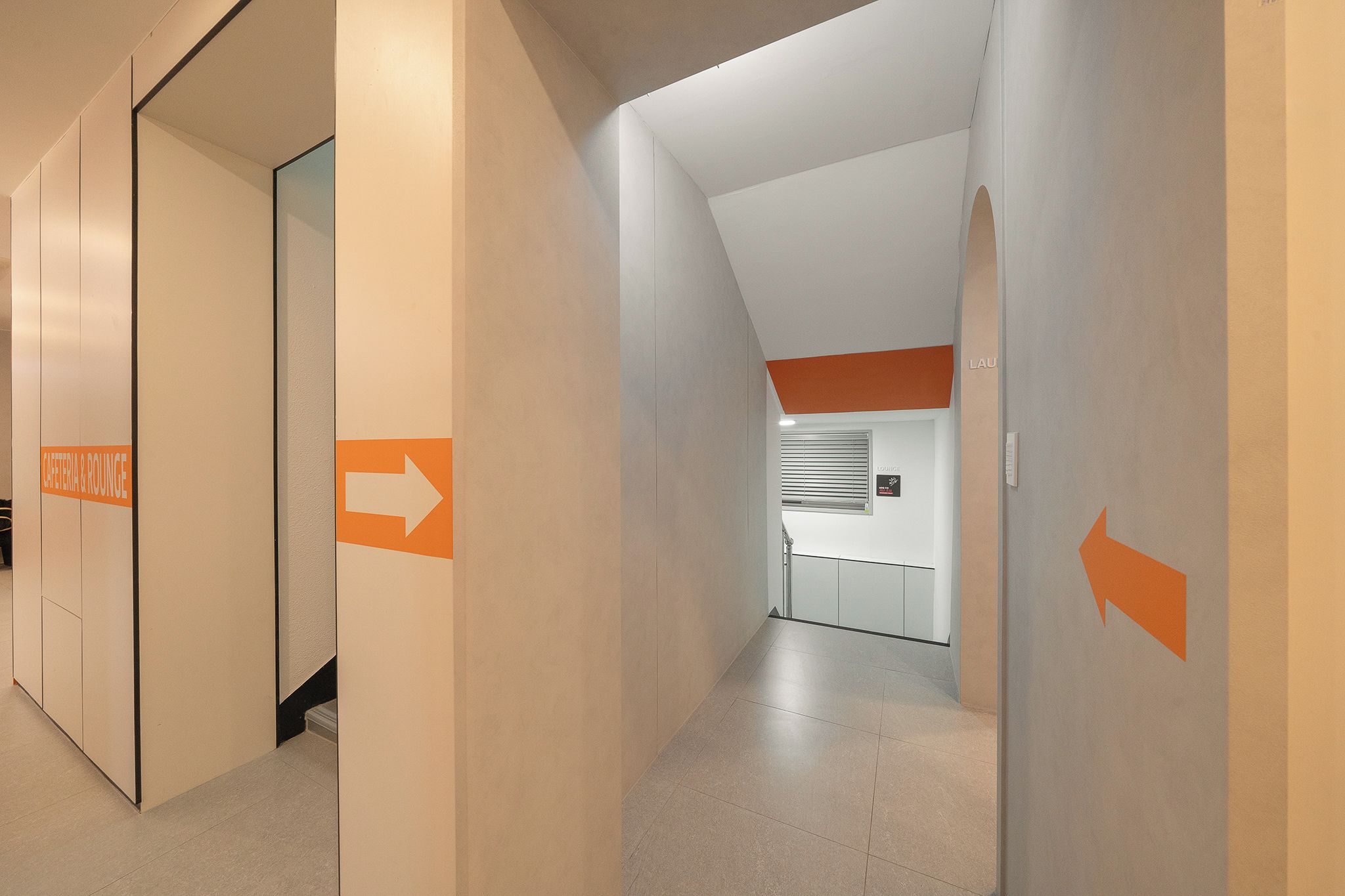 A corridor with directional arrows and a sign for the cafeteria & lounge.