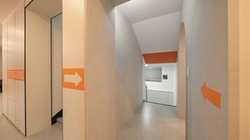 A corridor with directional arrows and a sign for the cafeteria & lounge.