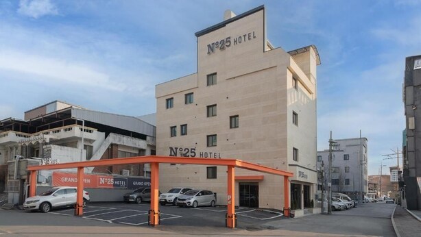 Un edificio de hotel con un cartel que dice 'No.25 Hotel' y un acceso cubierto.