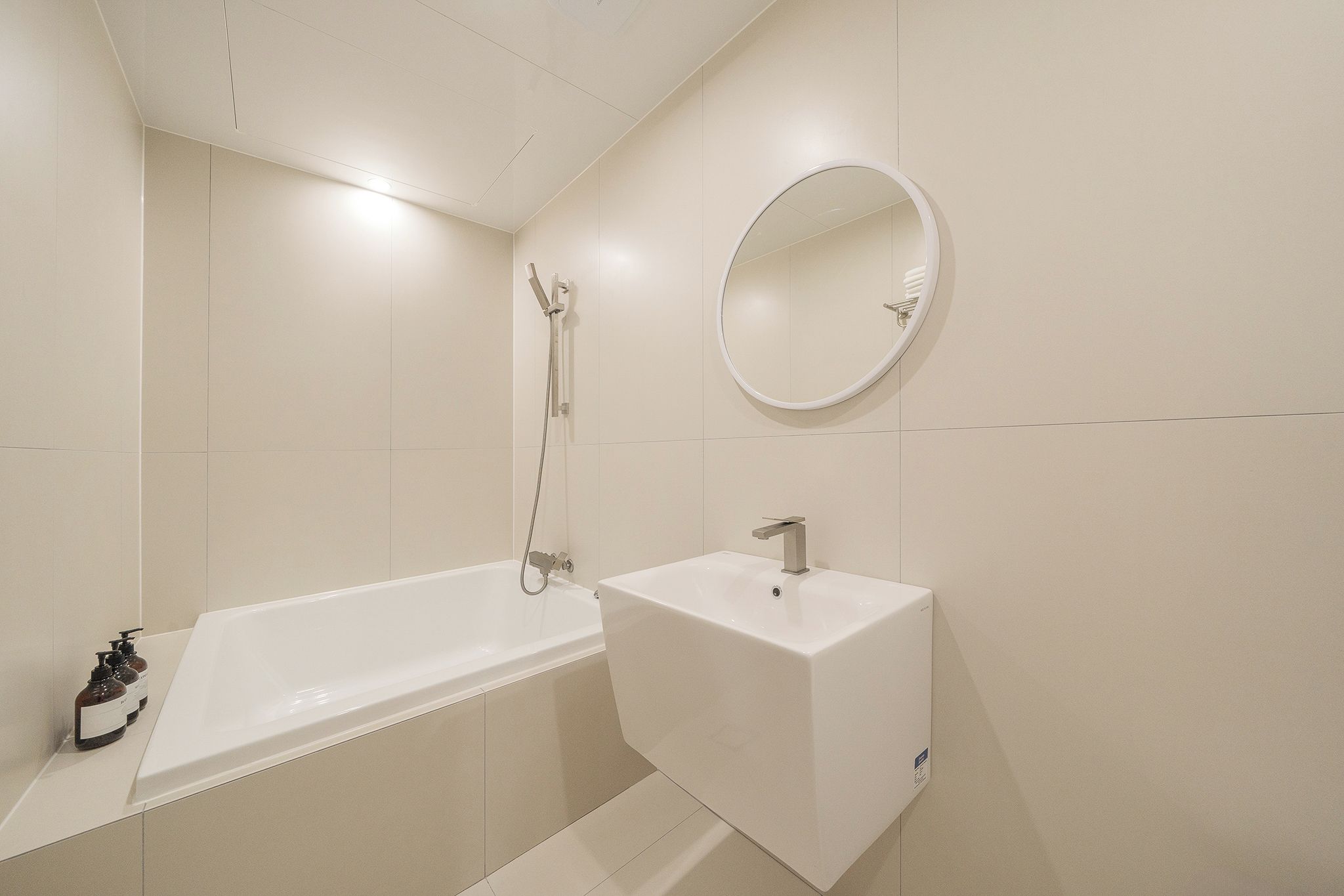A bathroom with a bathtub, a sink, and a mirror.
