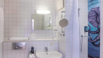 A bathroom with a sink, mirror, towel rack, and a shower.