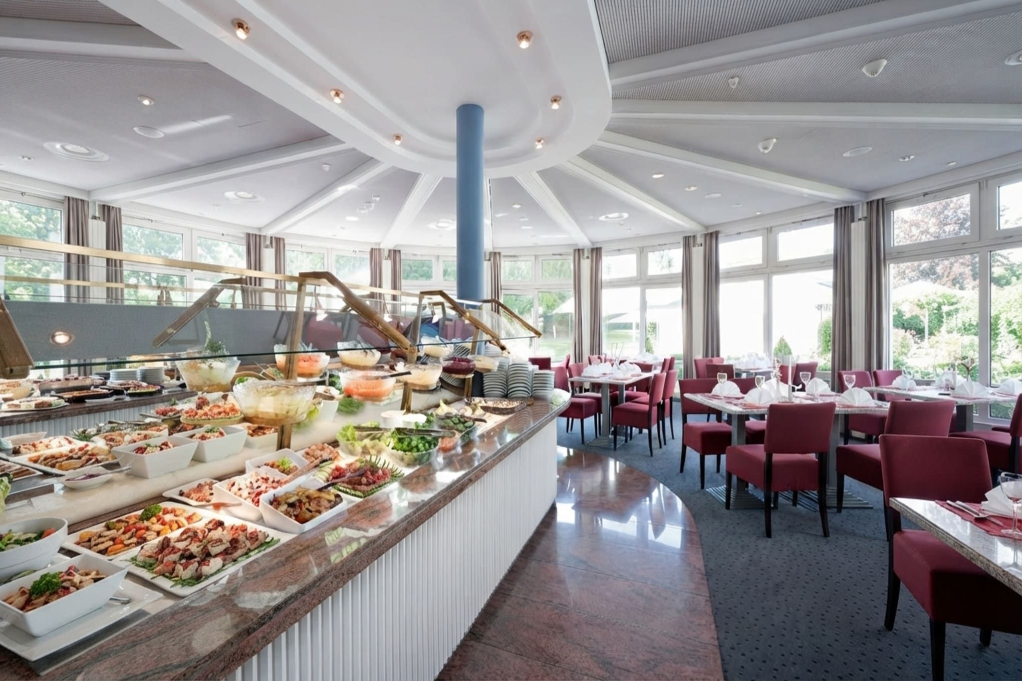 Ein Buffetbereich mit verschiedenen Speiseauslagen und einer Sitzgelegenheit mit Tischen und Stühlen.