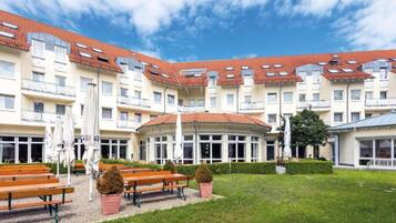 Ein Hotel mit mehreren Etagen, Außenbereich und einem gepflegten Garten.