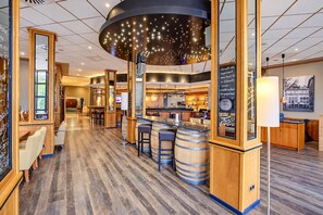 A modern bar area with wooden accents, a central bar counter, and a ceiling with a starry light fixture.
