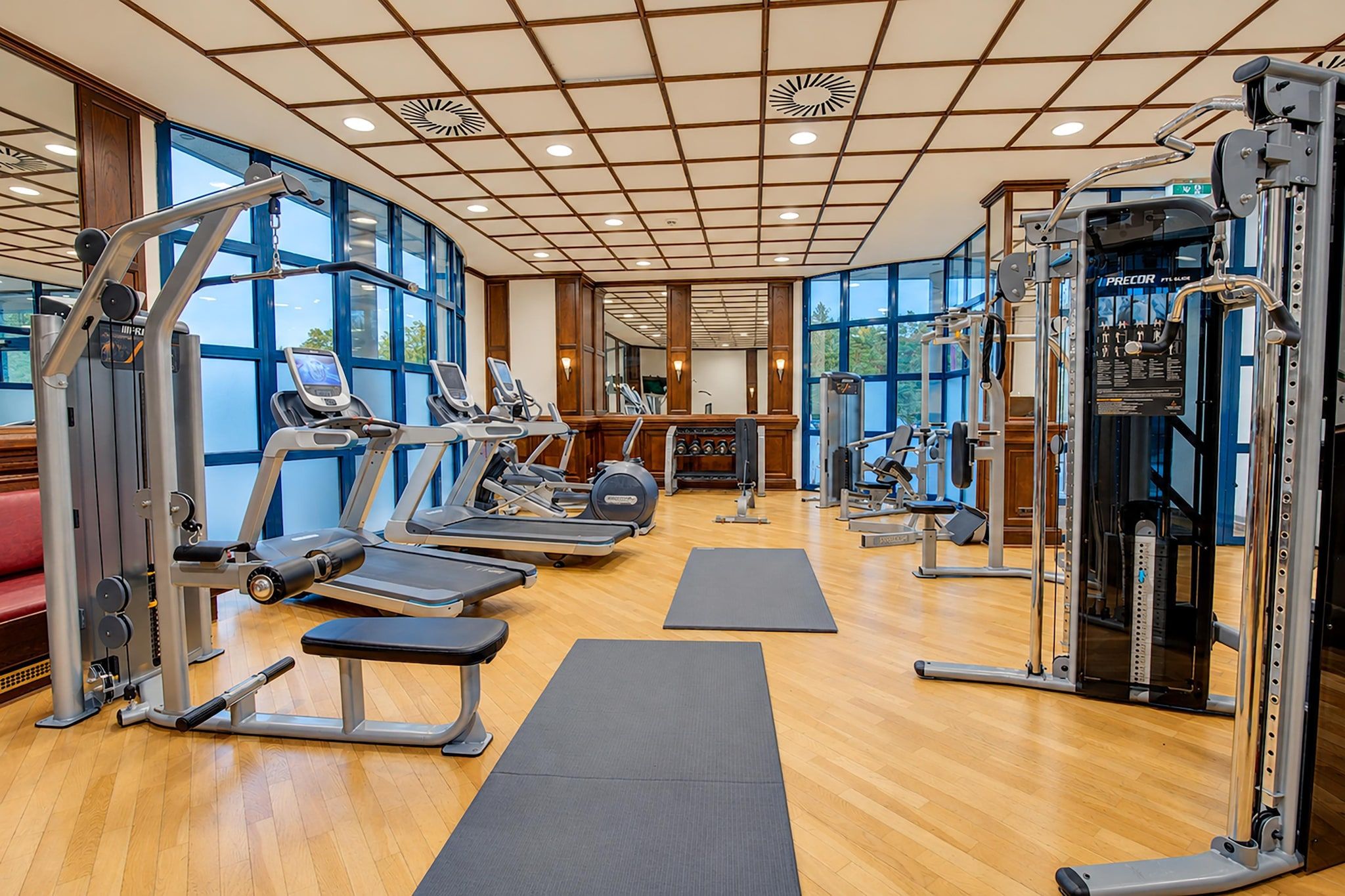 A gym with treadmills, weight machines, and mats.