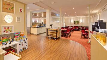 Ein Kinderspielbereich mit Lernspielzeug und eine Küchenecke mit Buffet.