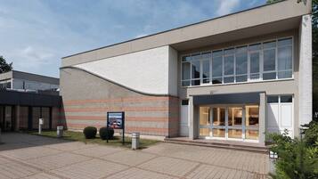 A modern building with a flat roof, large windows, and a brick facade.