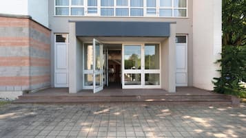 Un edificio moderno de dos pisos con entrada de vidrio y fachada de ladrillo.