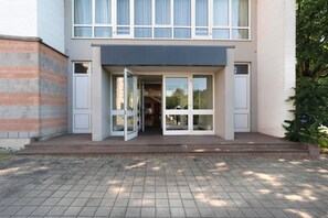 A modern two-story building with a glass entrance and a brick facade.