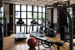A gym with treadmills, elliptical machines, and weight equipment.