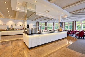 A modern restaurant with a central island, ample seating, and large windows offering views.