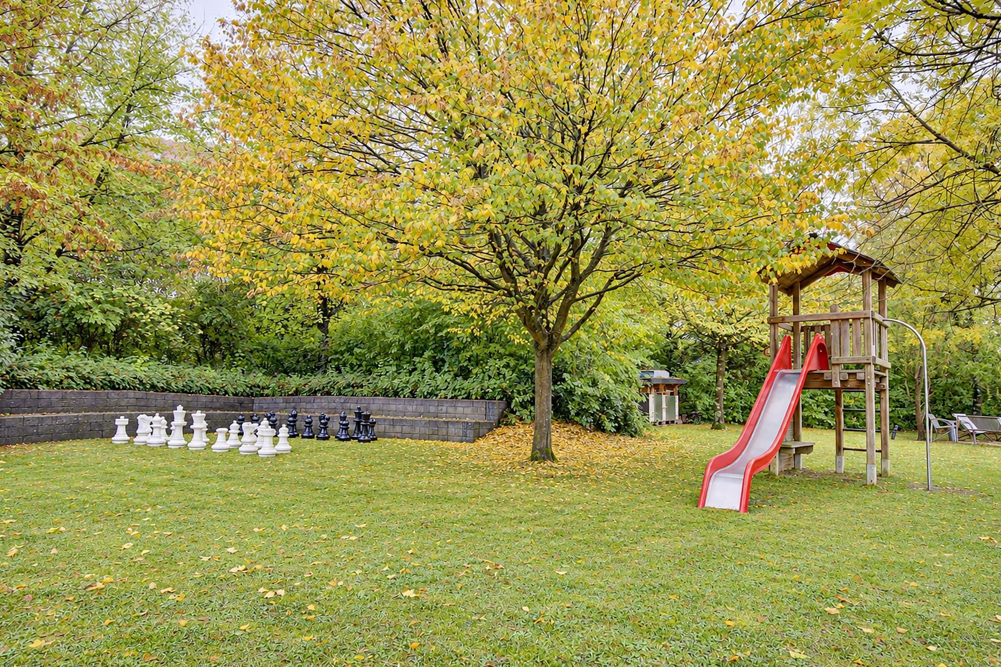 Un parque infantil con un tobogán y un tablero de ajedrez.