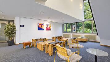 Ein modernes Interieur mit hoher Decke, Holzmöbeln und großen Fenstern.