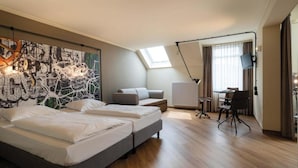 Una habitación de hotel moderna con una cama grande, un escritorio y un cuadro en la pared.