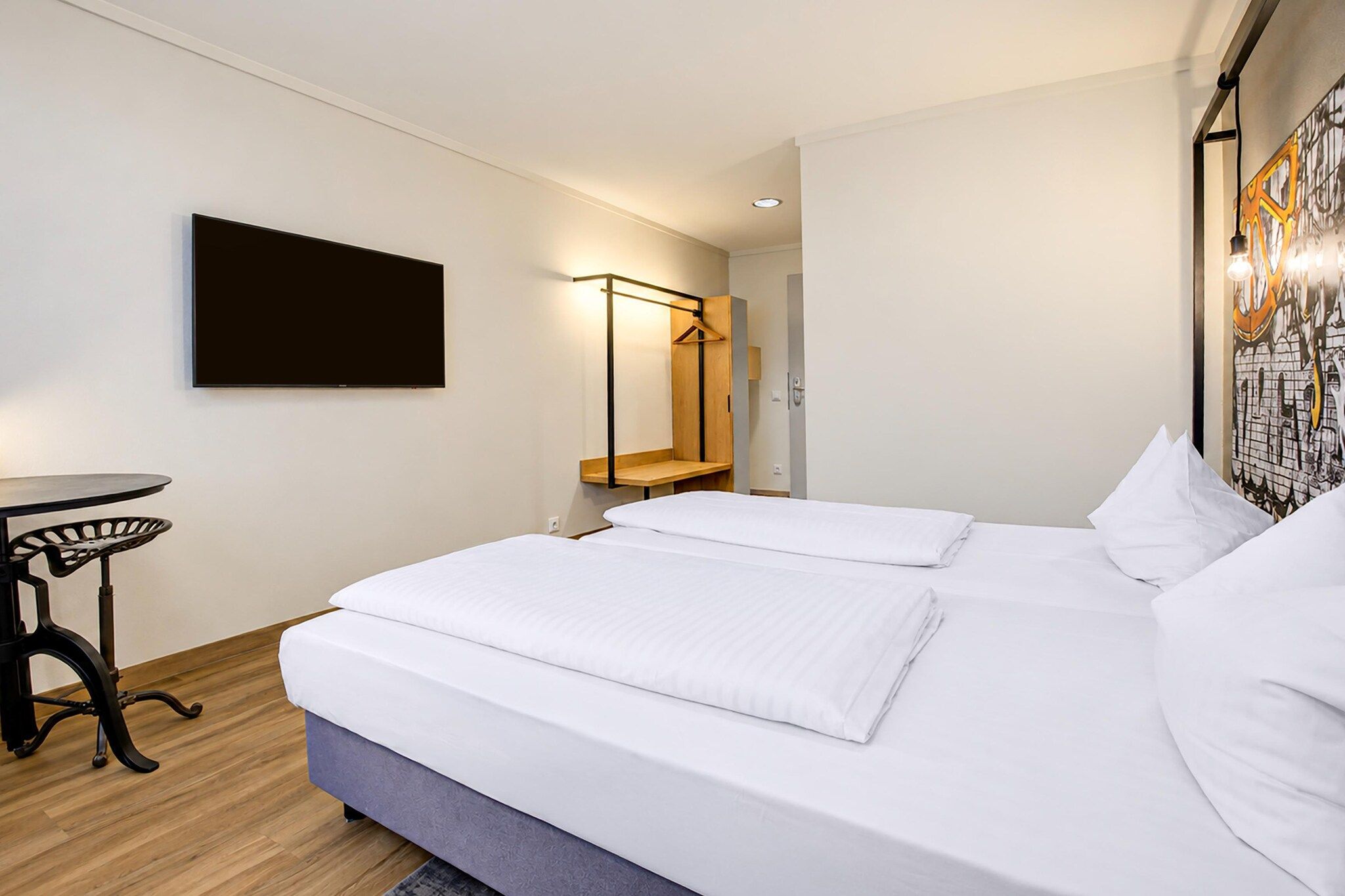 Ein Hotelzimmer mit einem Bett, einem Schreibtisch und einem Kleiderhaken.