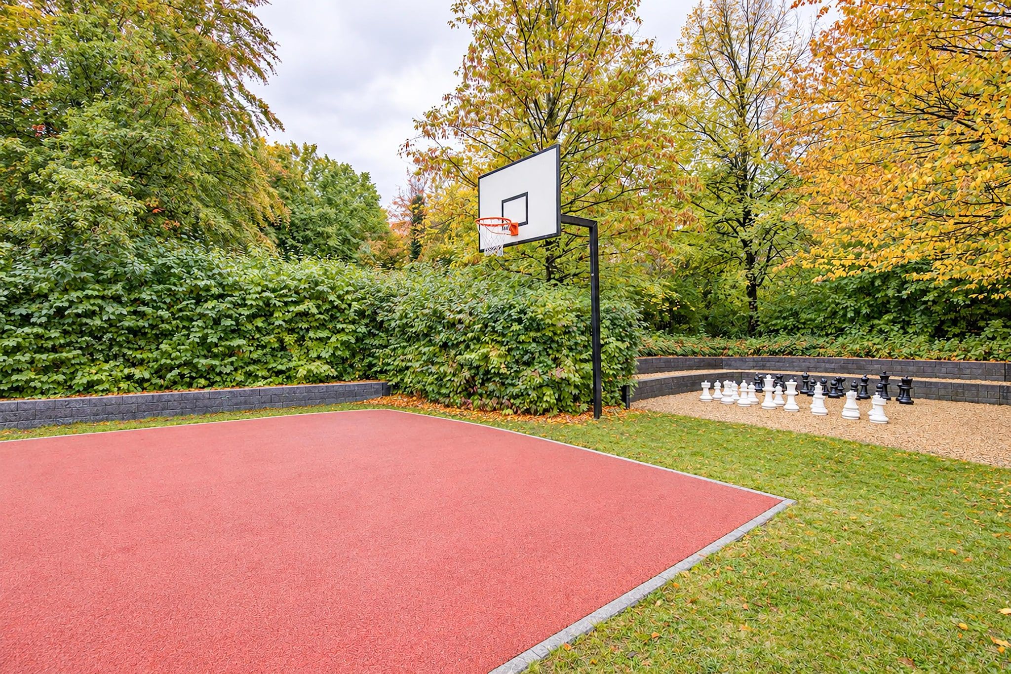 Ein Basketballplatz im Freien mit einem Korb und einem Schachbrett.