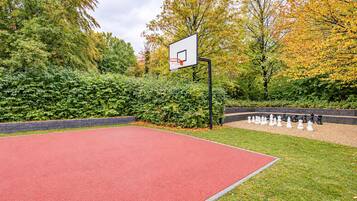 Ein Basketballplatz im Freien mit einem Korb und einem Schachbrett.