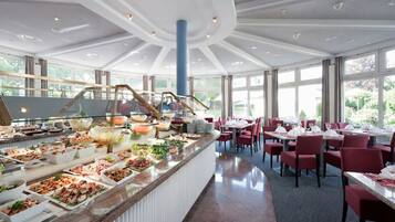 Un espace buffet avec différents stands de nourriture et un coin repas avec des tables et des chaises.