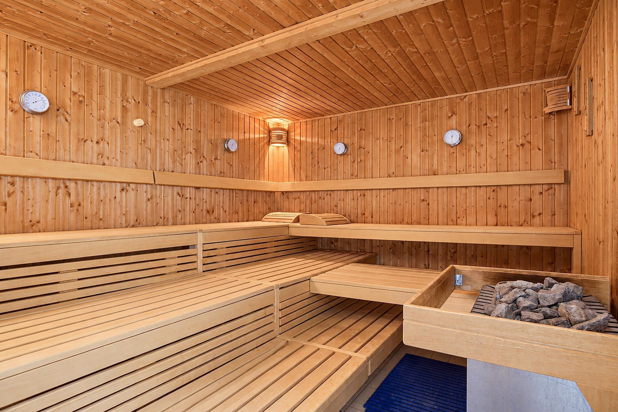 A sauna with wooden benches and a stone basin.