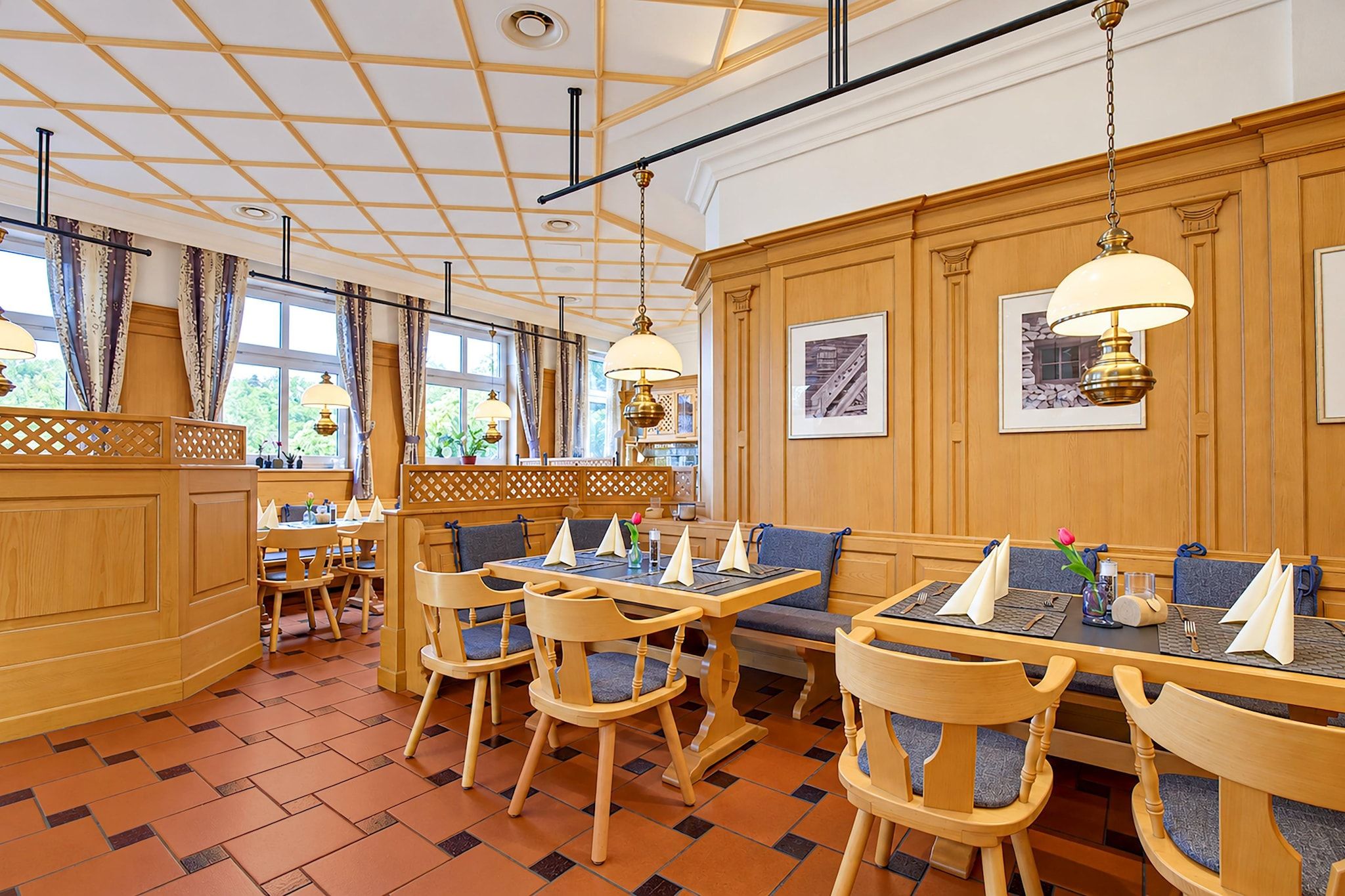 Een restaurant met houten meubels, een betegelde vloer en hanglampen.