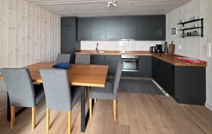 A compact kitchen with dark cabinets, a wooden countertop, and a built-in oven.