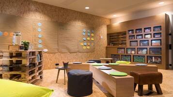 A modern interior with a wooden wall, a reception desk, and a seating area with cushions.