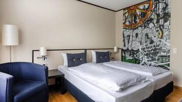 Et hotelværelse med en dobbeltseng, to sengeborde, en stol og et stort abstrakt billede på væggen.