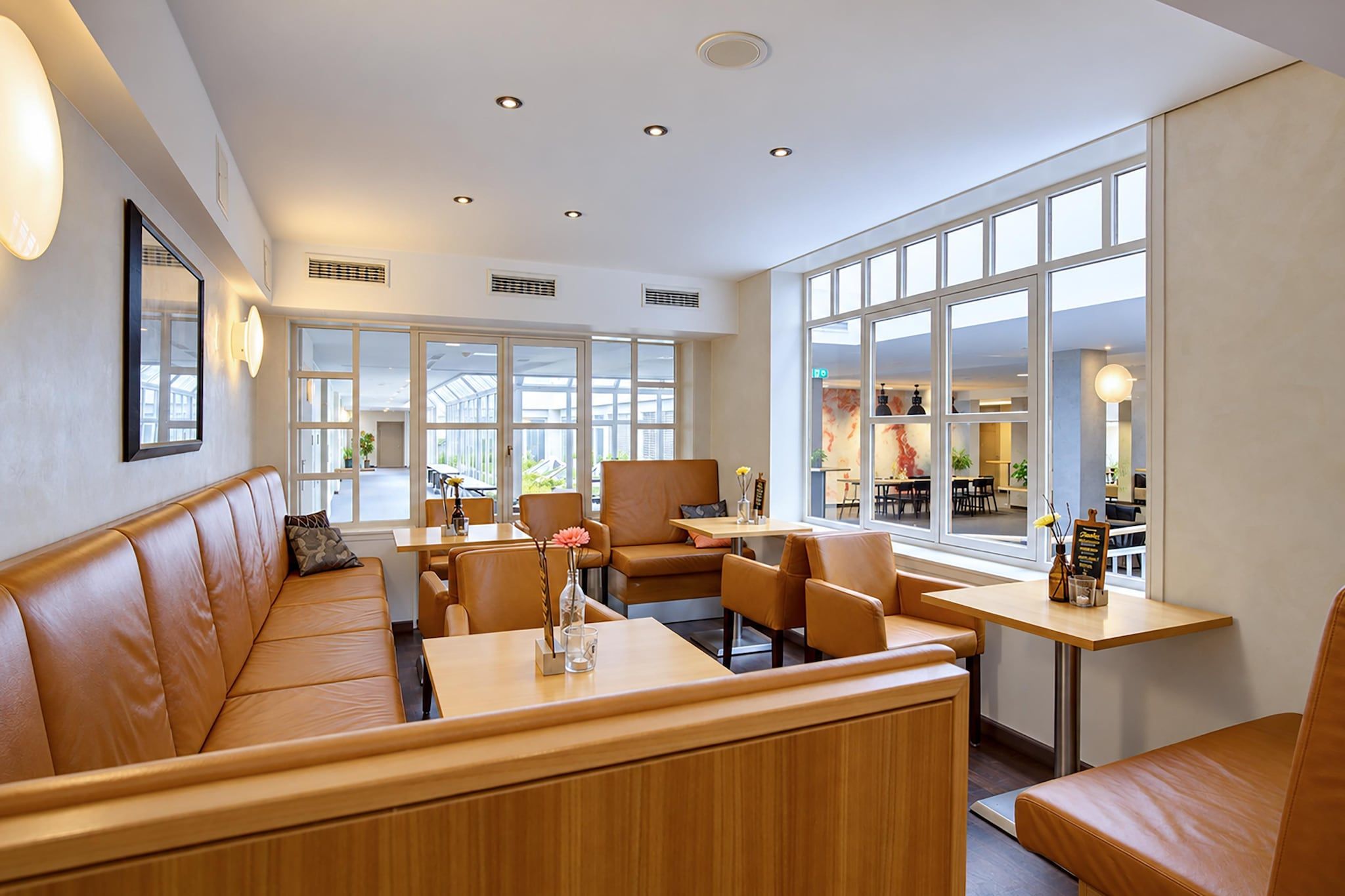 A modern interior with a seating area, tables, and large windows.