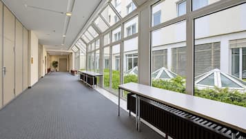 A corridor with large windows, a radiator, and a table.