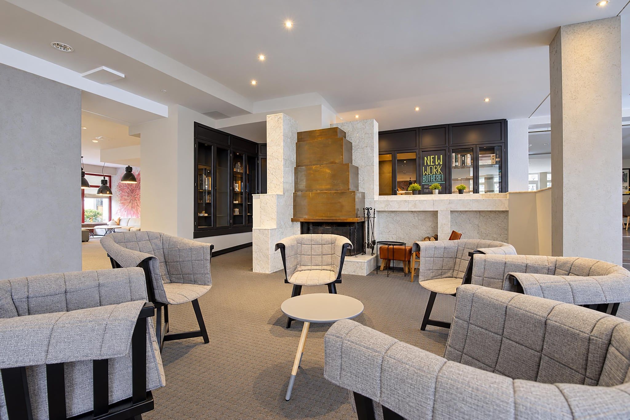 A modern lounge area with sofas and a fireplace.