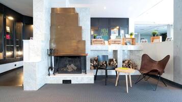 A modern interior with a fireplace, seating area, and a work station.