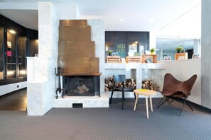 A modern interior with a fireplace, seating area, and a work station.