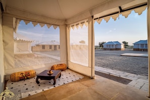 A tented room with a view of traditional buildings outside.
