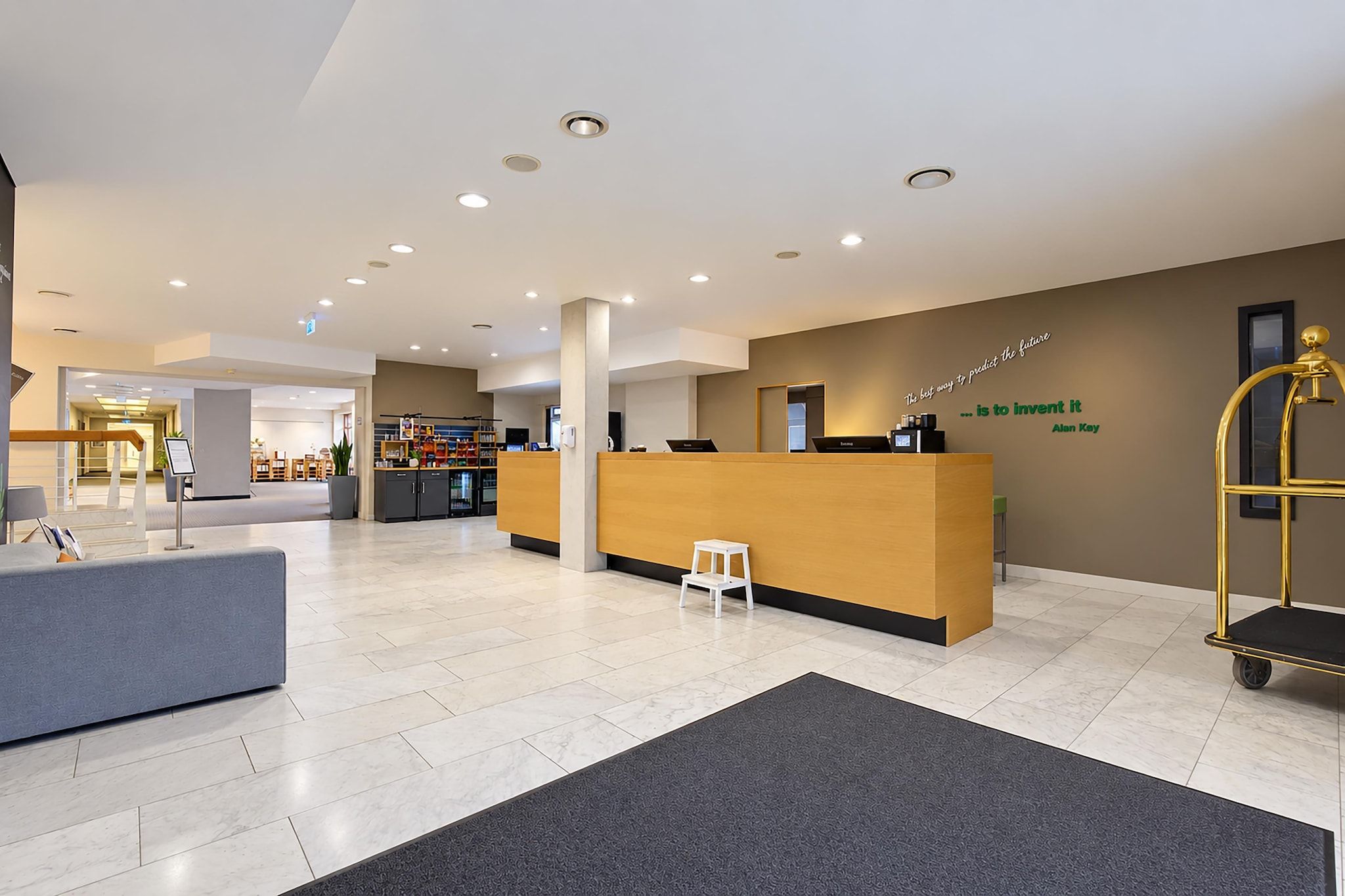 A modern reception area with a reception desk, seating area, and a wall with a motivational quote.