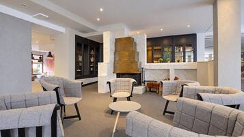 Un espace de détente moderne avec des canapés et une cheminée.
