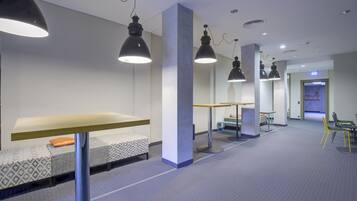 Un intérieur moderne avec un long couloir, des espaces de détente et des luminaires suspendus.