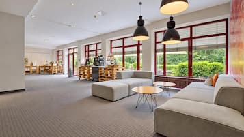 A spacious lobby with a seating area, large windows, and a coffee station.