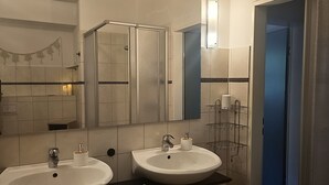 A bathroom with two sinks, a mirror, and a shower enclosure. - Apartment 1 – Schrappmühle with Terrace, Garden, Wi-Fi, and Rural Seclusion (Aerzen)