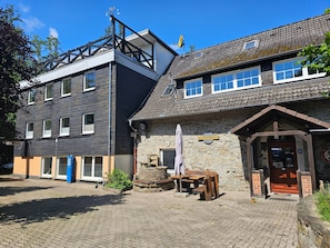 A building with a stone facade, a wooden bench, and a sign reading 'SCHRAPPMÜHLE.'
