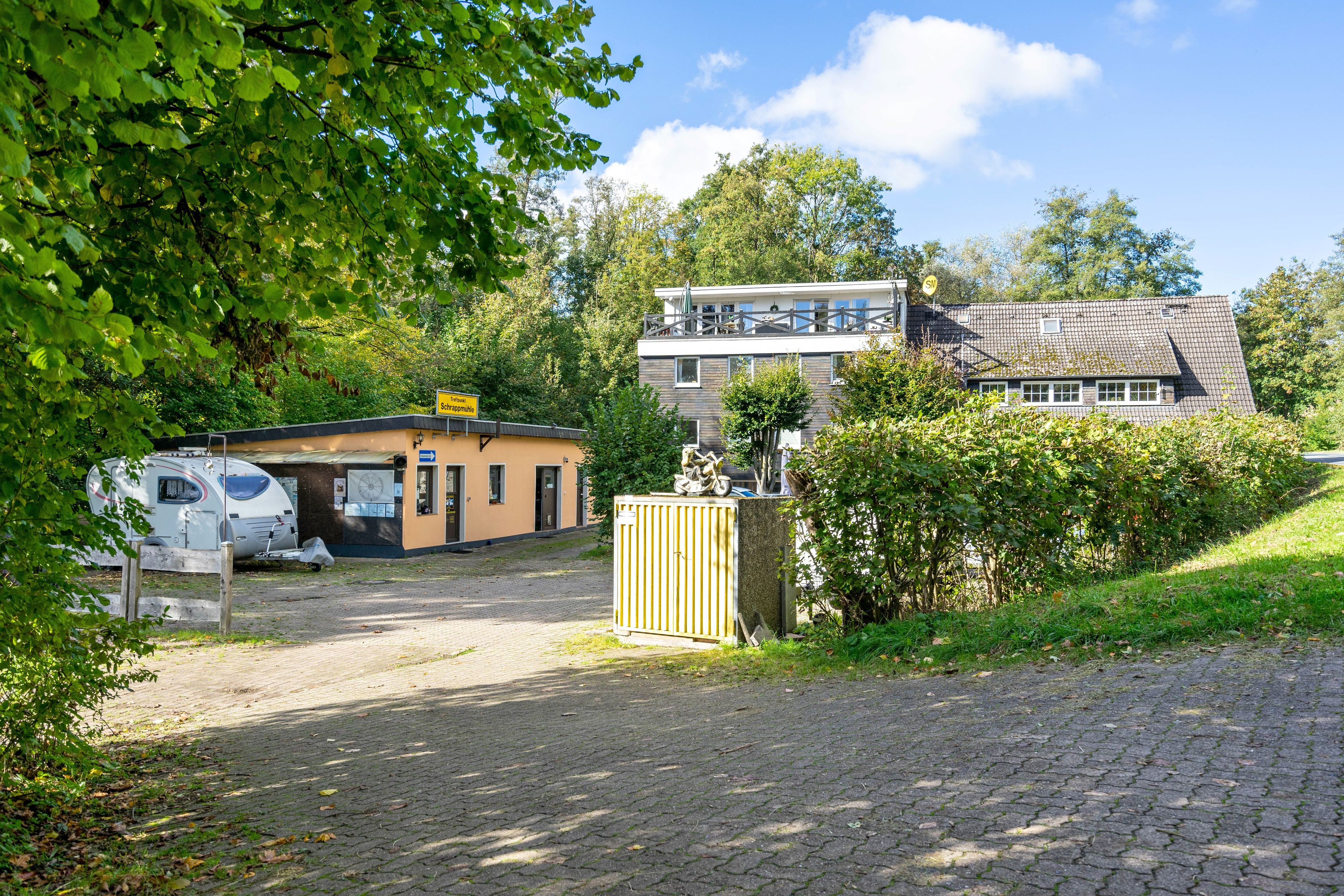 Ein zweistöckiges Gebäude mit einem gepflasterten Weg, der zu einem verschlossenen Eingang führt.