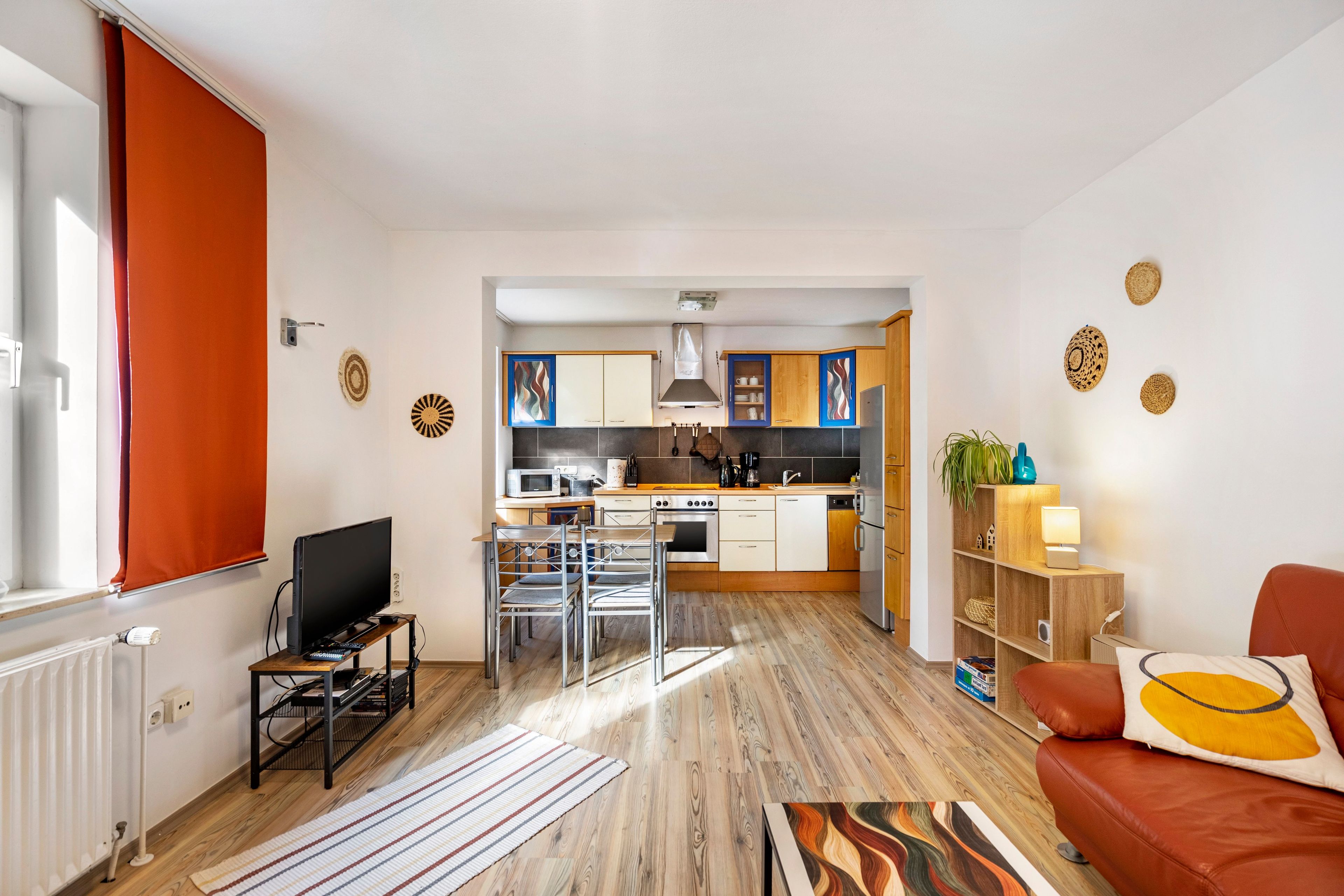 A modern apartment with a living room, kitchen, and dining area.