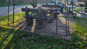 En park med et overdækket picnicområde, bænke og en anlagt sti.