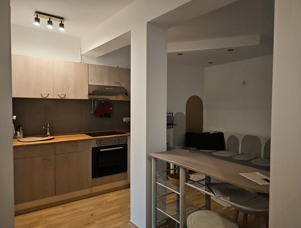 Eine moderne Küche mit Holzausstattung, einem Backofen und einem Essbereich mit Tisch und Stühlen.