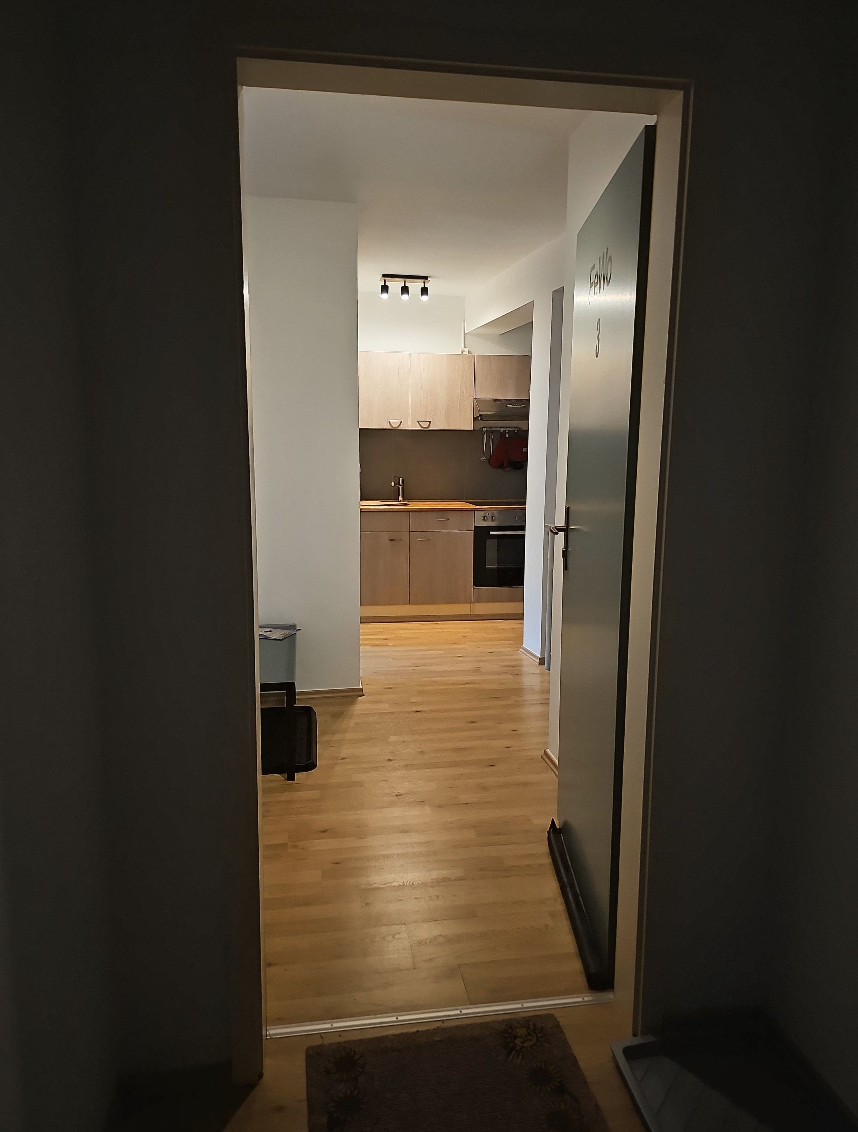 Una cocina moderna con armarios de madera, un refrigerador de acero inoxidable y un horno empotrado.