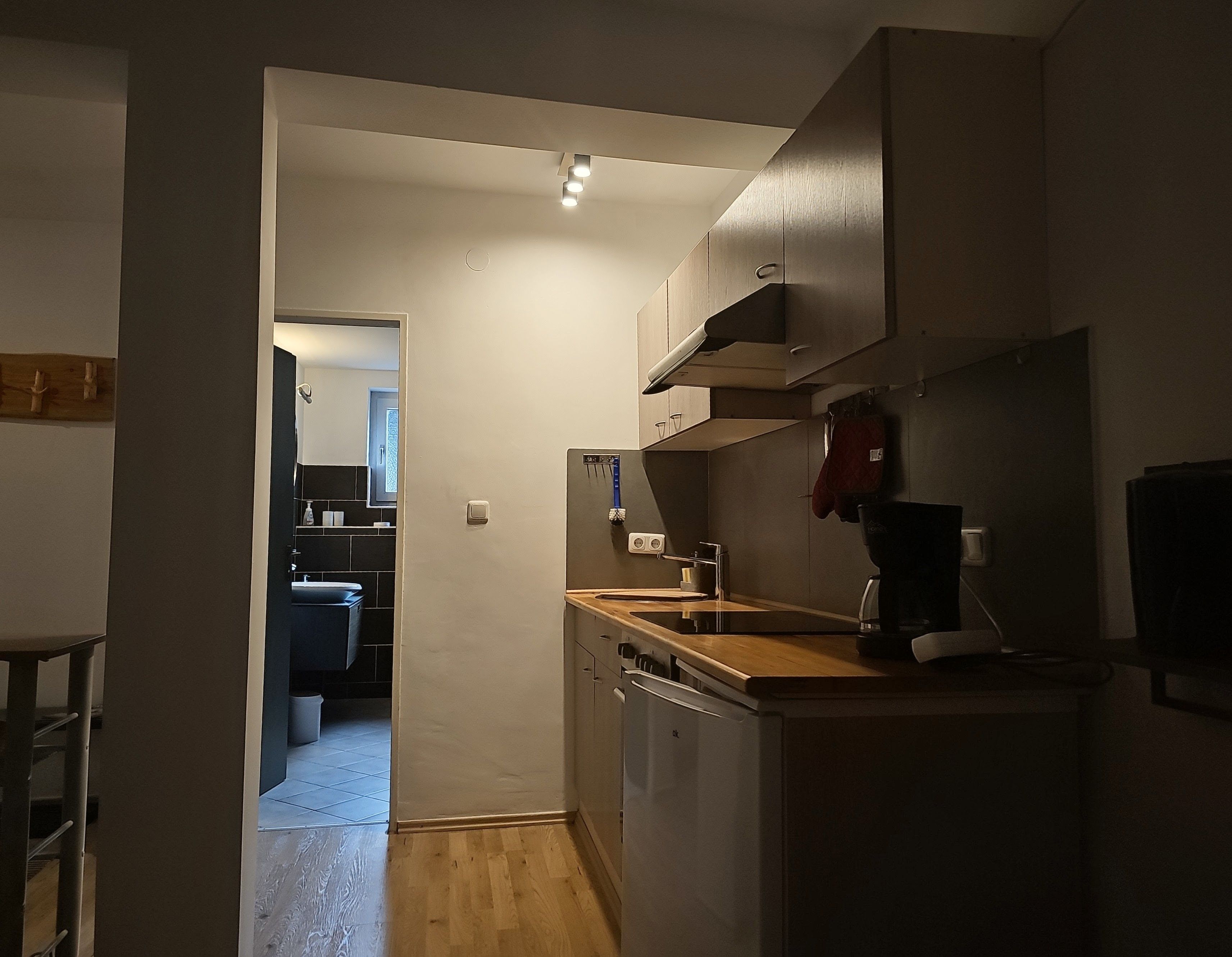 A compact kitchen with a dishwasher, a coffee machine, and a microwave.