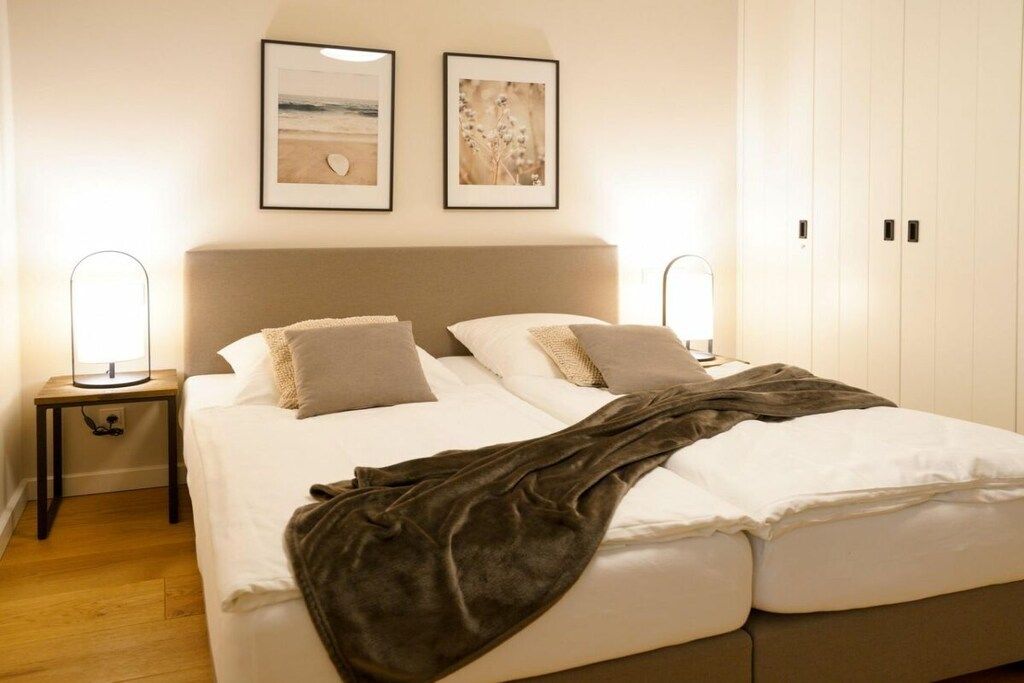 Una camera da letto con un letto, comodini e un'opera d'arte appesa al muro.