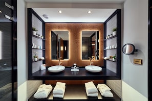 A modern bathroom with two sinks, a large mirror, and a towel rack with folded towels. - La Pyramid (Vienne)