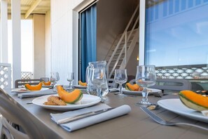 A table set for a meal with plates, cutlery, and a pitcher of water. - Les Terrasses De Fort Boyard (Fouras)