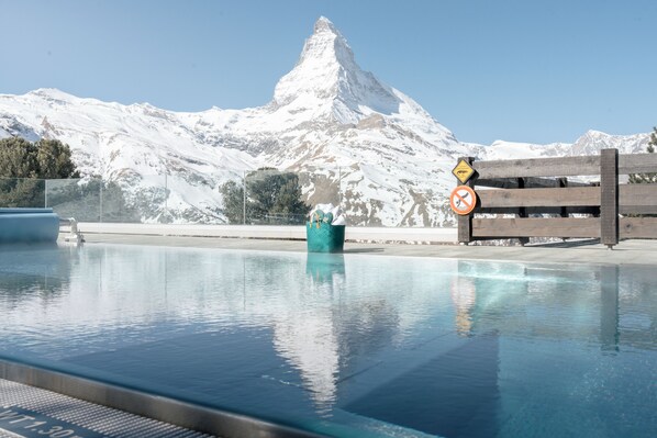 Ein Schwimmbecken vor einer Bergkulisse.