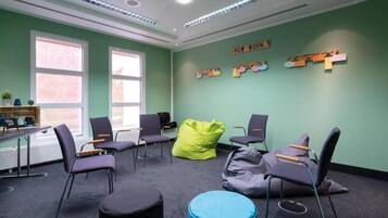 A room with multiple chairs, a bean bag, and a desk with a computer.